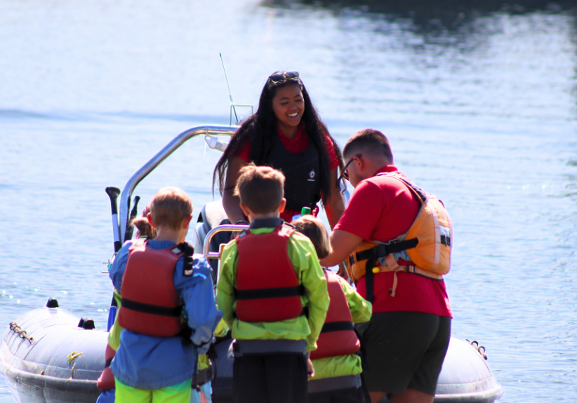 Cobnor Activities Centre Trust Instructors helping children onto Powerboat