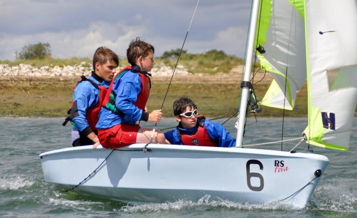 Teens sailing on Feva boat across Chichester Harbour