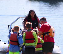 Cobnor Activities Centre Trust Instructors helping children onto Powerboat