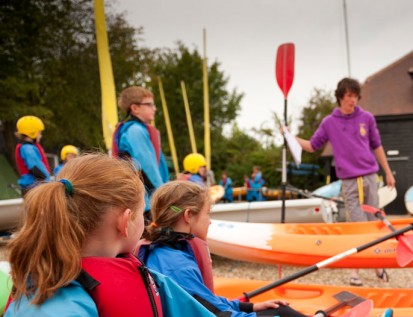 Instructor teaching children how to Kayak